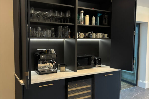 Kitchen coffee station with bespoke cabinetry, quartz worktops, wine cooler and integrated lighting