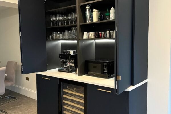 Dark blue kitchen cabinetry with concealed drinks storage and integrated lighting