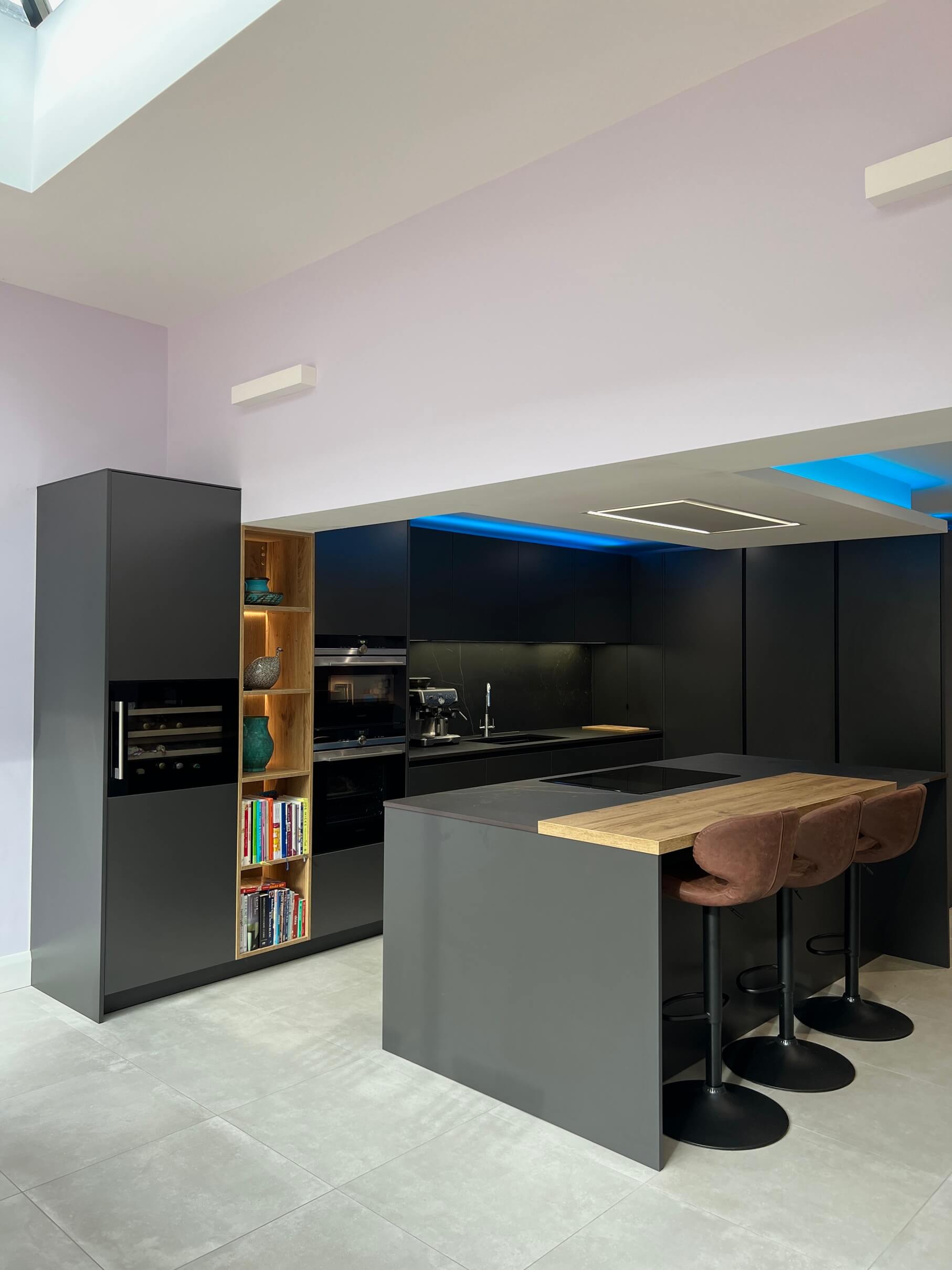 Dark graphite kitchen with natural oak island worktop and illuminated shelving